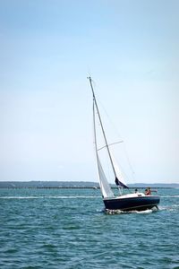 Sailboat on sea against clear sky