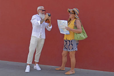 Full length of woman standing against wall