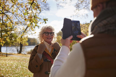 Man photographing woman with cell phone