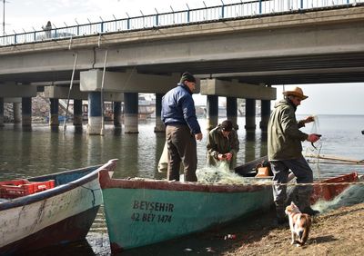 People on boat against bridge