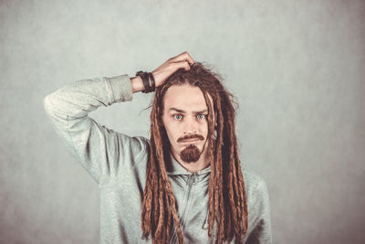 Portrait of young man standing against wall