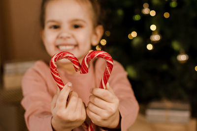 A young girl is holding a christmas gift in her hands.