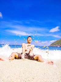 Full length of man sitting on beach