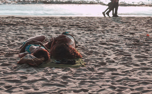 Couple lying at beach during sunset