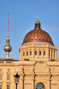 The famous tv tower and the cupola of the rebuilt berlin city palace just before sunset