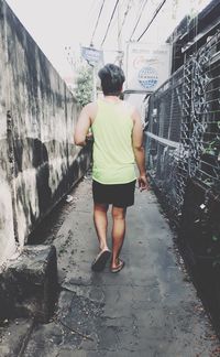 Rear view of boy standing on wall