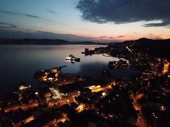 High angle view of illuminated cityscape against sky at sunset