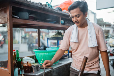 Portrait of young man working in kitchen