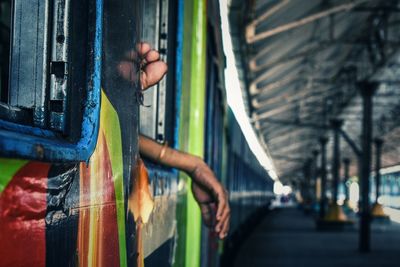 Cropped hands at train window in railroad station