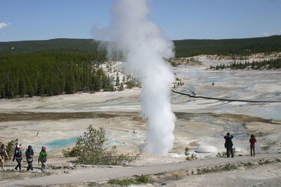 Rear view of people on landscape against mountain