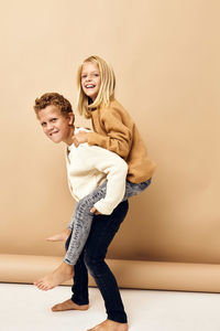 Portrait of brother carrying sister on back