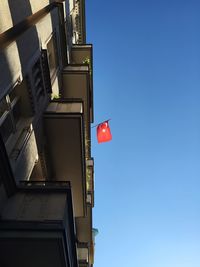 Low angle view of building with turkish flag against clear sky