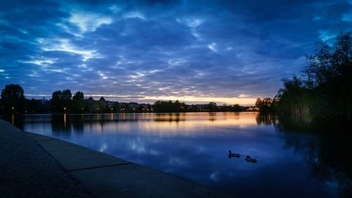 Scenic view of calm lake against cloudy sky