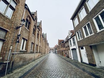 Narrow alley amidst buildings against sky