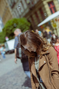 Smiling young woman standing on street in city