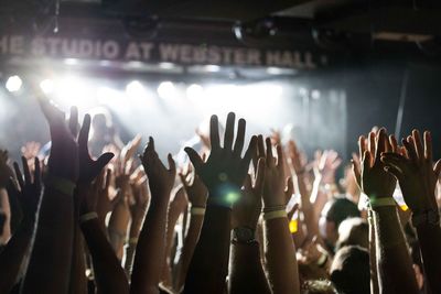 Group of people with arms raised enjoying at music concert