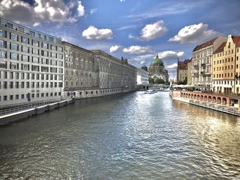 Bridge over river against buildings in city