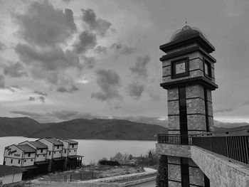 Tower by building in city against sky