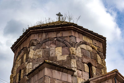 Low angle view of old building against cloudy sky