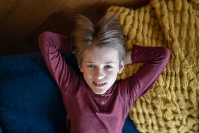 Portrait of smiling young woman sitting on sofa at home