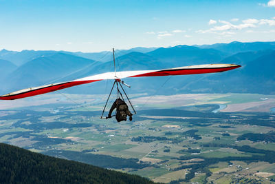 Airplane flying over mountains against sky