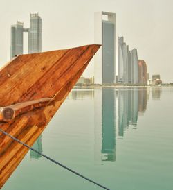 Reflection of buildings in sea against sky