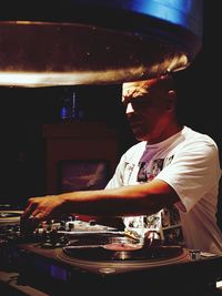 Man playing sound mixer standing by table