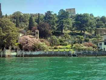 Scenic view of river by buildings against sky