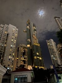 Low angle view of illuminated buildings against sky at night