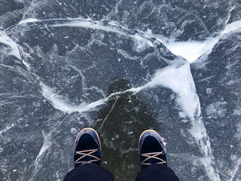 Low section of person standing on snow