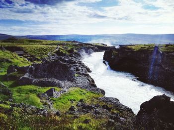 Scenic view of waterfall against sky