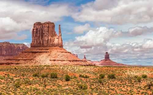 Rock formations on landscape against cloudy sky