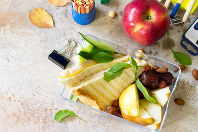 Back to school background with school supplies, lunch box and apple. 