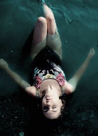 High angle view of young woman lying in lake