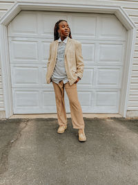 Full length of young woman standing against the garage door 