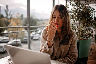 Mexican woman chats with friends, enjoys morning coffee on cafe terrace. digital life, slow living