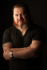 Portrait of mid adult man against black background