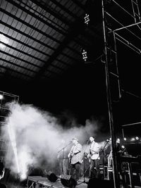 Panoramic view of crowd at music concert at night