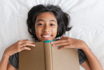 Portrait of a smiling young woman holding box at home