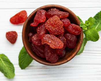 Dried strawberries in bowl on a vintage background