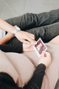 Midsection of couple holding hands at home