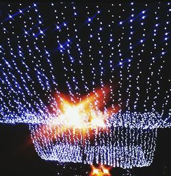 Close-up of illuminated fireworks against sky at night