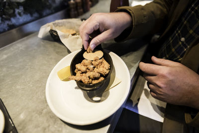 Midsection of person holding ice cream in restaurant