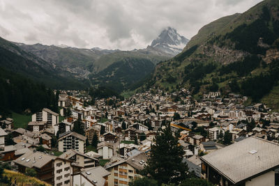 Aerial view of townscape and mountains against sky