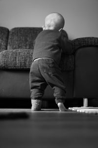 Rear view of boy sitting on sofa
