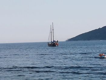 Ship sailing on sea against clear sky