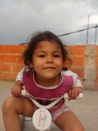 Portrait of smiling girl sitting outdoors