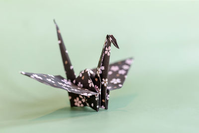 Origami crane on a pale mint background