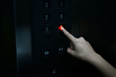 Close-up of person hand on illuminated electric lamp