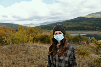 Portrait of young woman standing on land